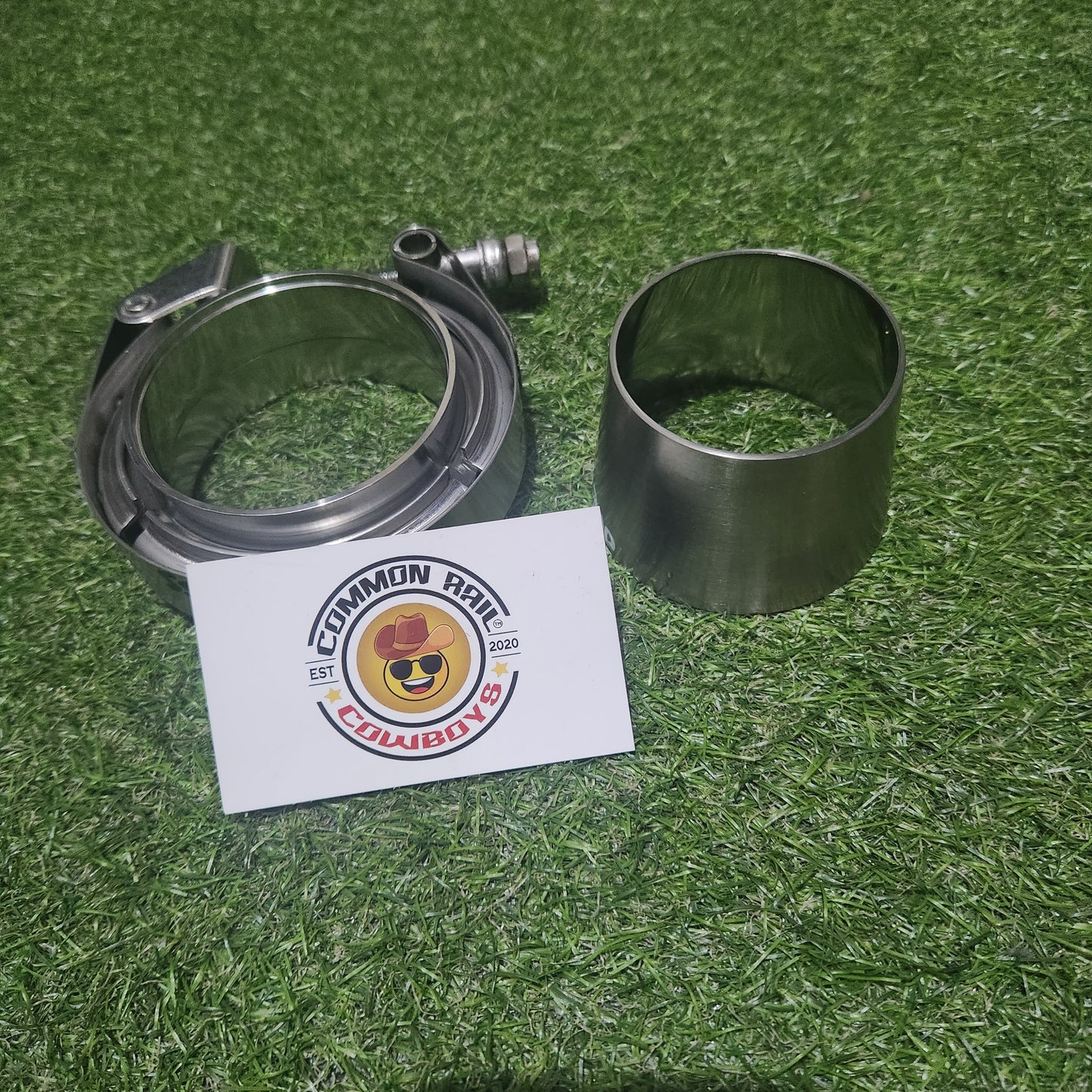 Common Rail Cowboys 2.5 to 3 inch dump pipe adapter kit for exhaust systems, shown with metal fittings and clamps.