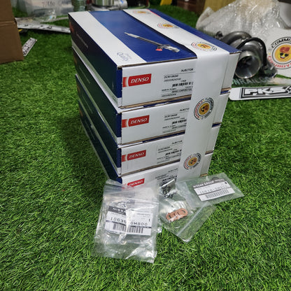 Denso Navara D40 YD25 fuel injectors, genuine automotive parts, with metal and plastic components visible in the image.