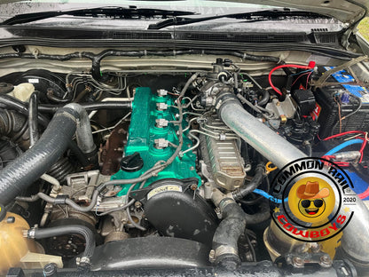 Colorful aluminium rocker cover for diesel engine by Common Rail Cowboys, featuring vibrant finish and detailed craftsmanship.