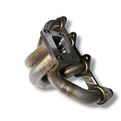 Stainless steel 1KD T3/T4 exhaust manifold by PPRC showing the polished metal surface and mounting ports.